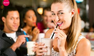 Girl is drinking shake and smiling and thats what are the characteristics of self confidence.