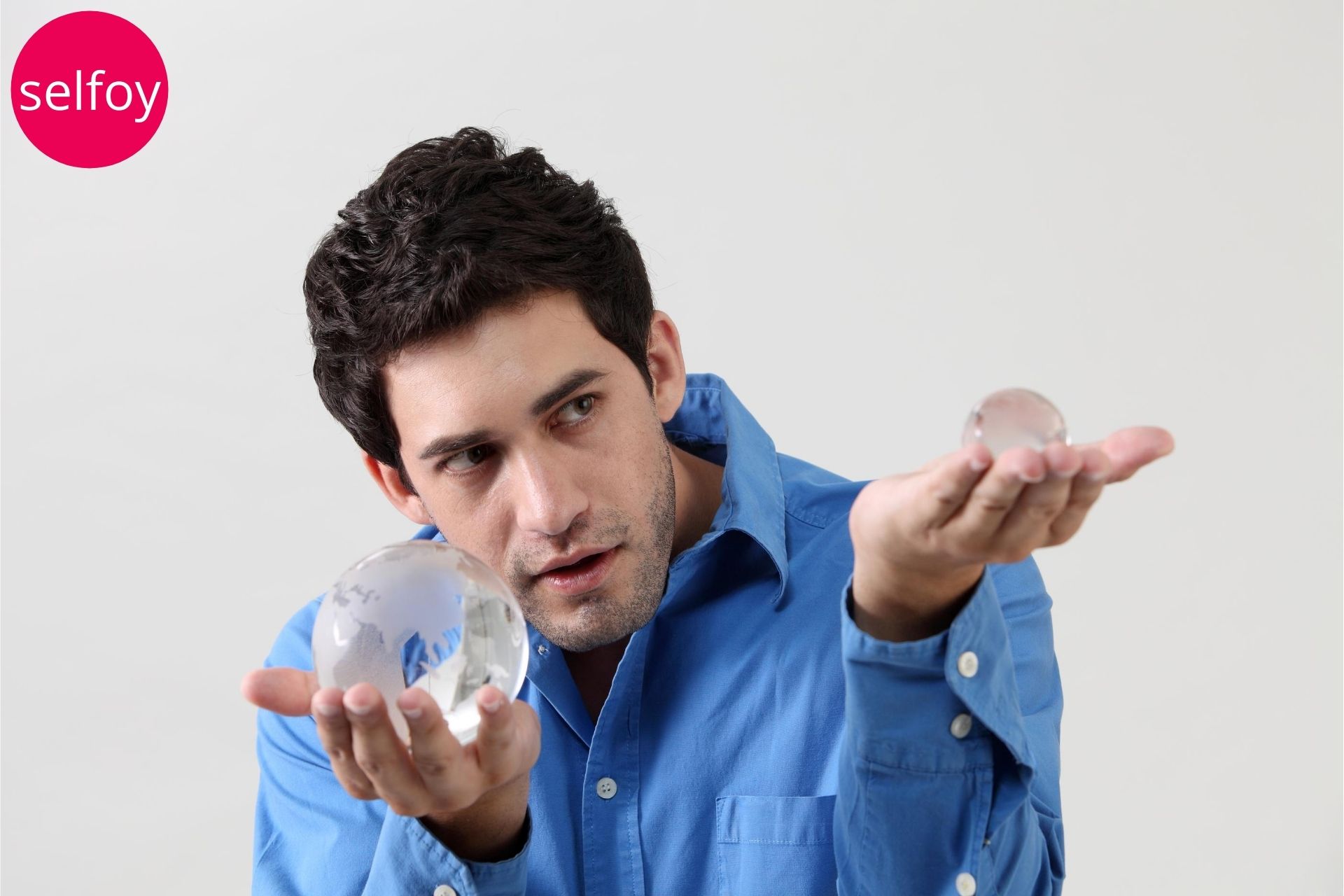man holding two glass balls in two hands