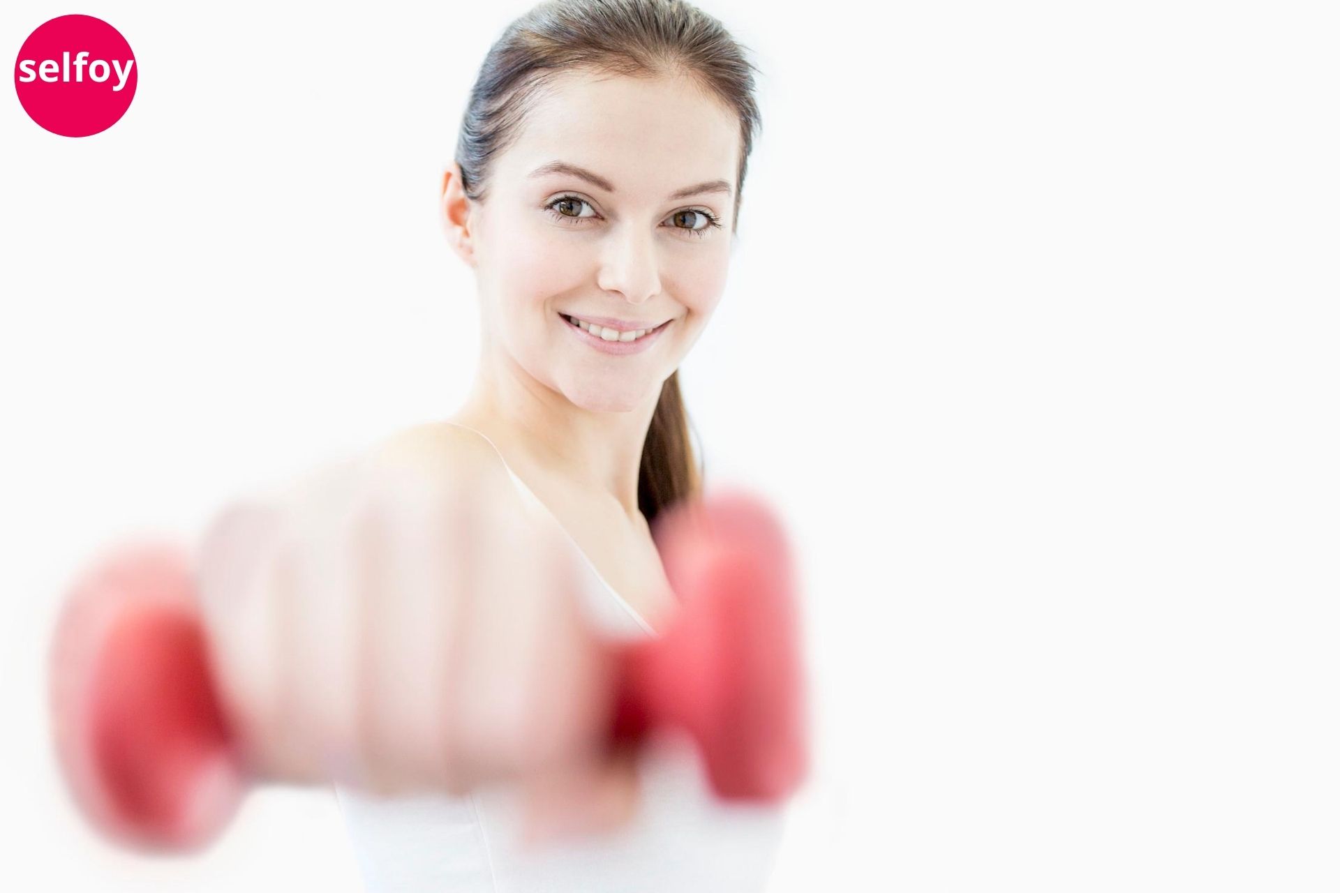 Girl smiling and showing red dumbbell 