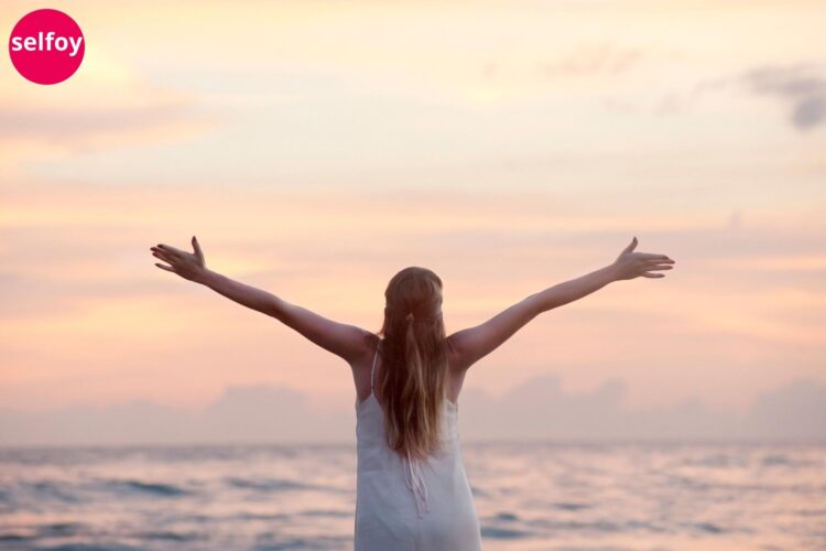 Woman opening her hands wide and showing Optimism, Trust and Self confidence are components of emotional wellness.