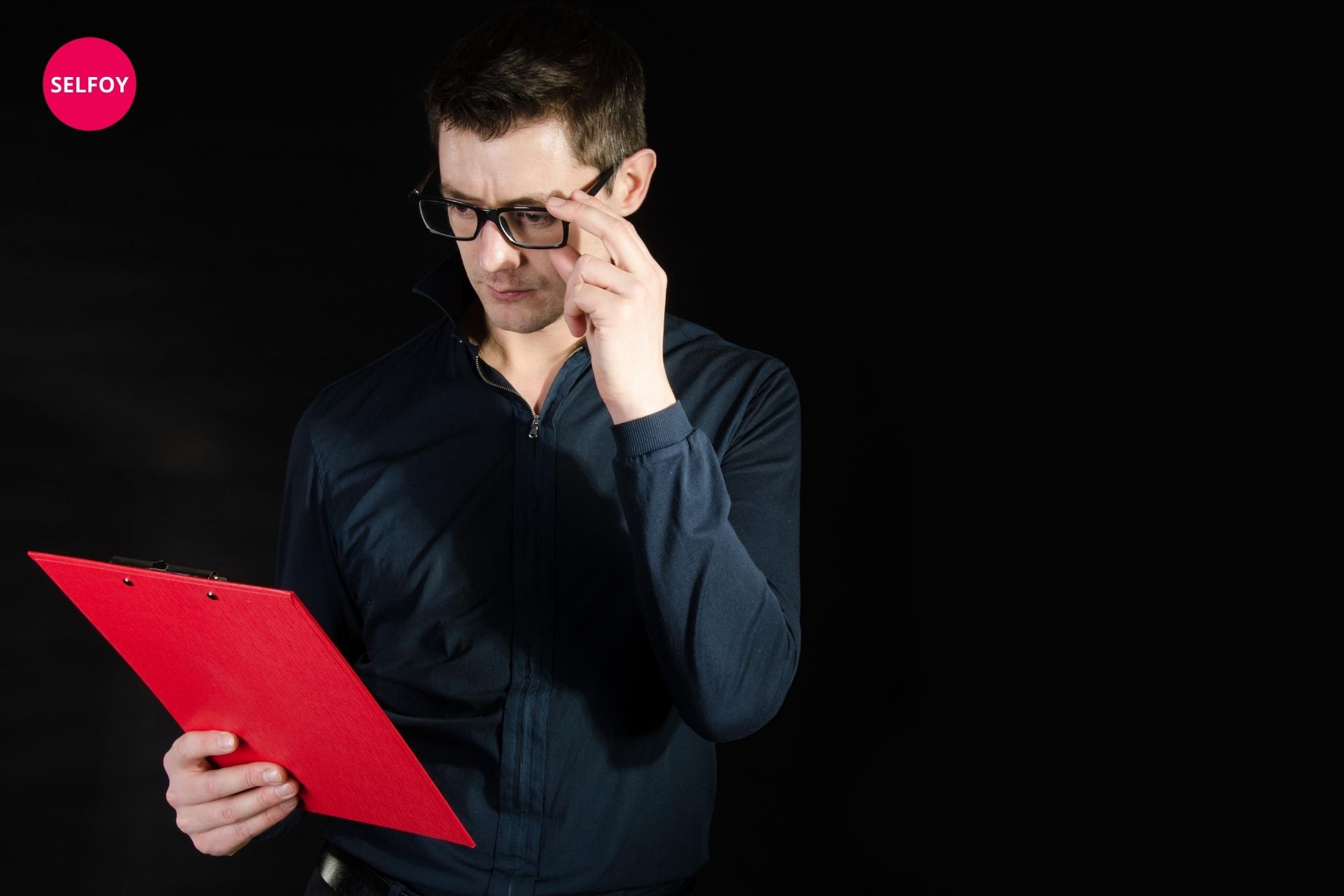 man wearing black shirt holding red file written about does autodidact work with self care to her team