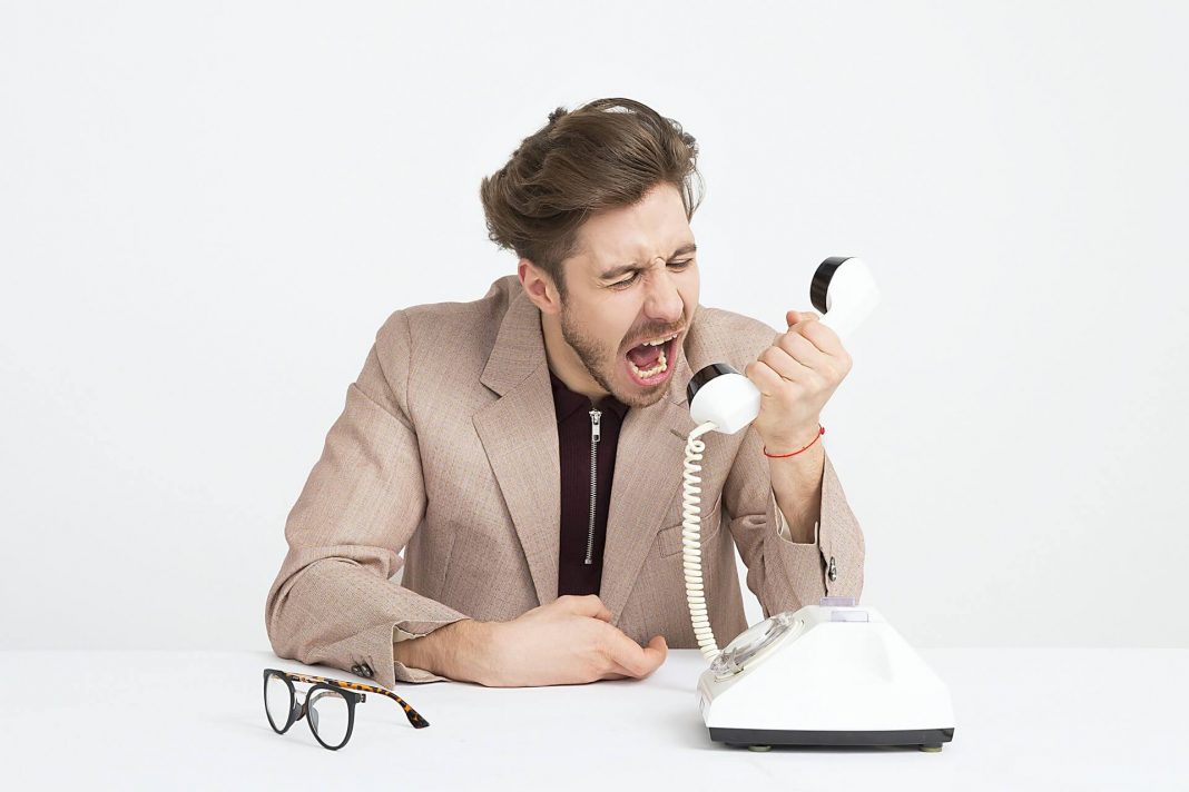 Person-wearing-brown-blazer-shouting-on-spam-call