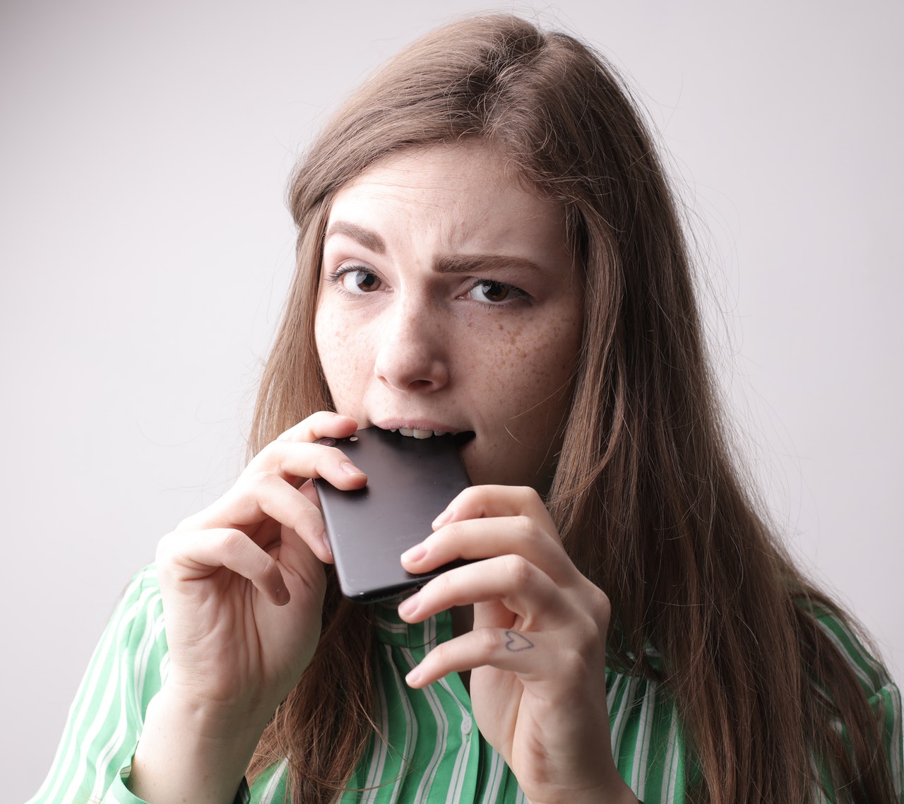 Girl is holding mobile at mouth