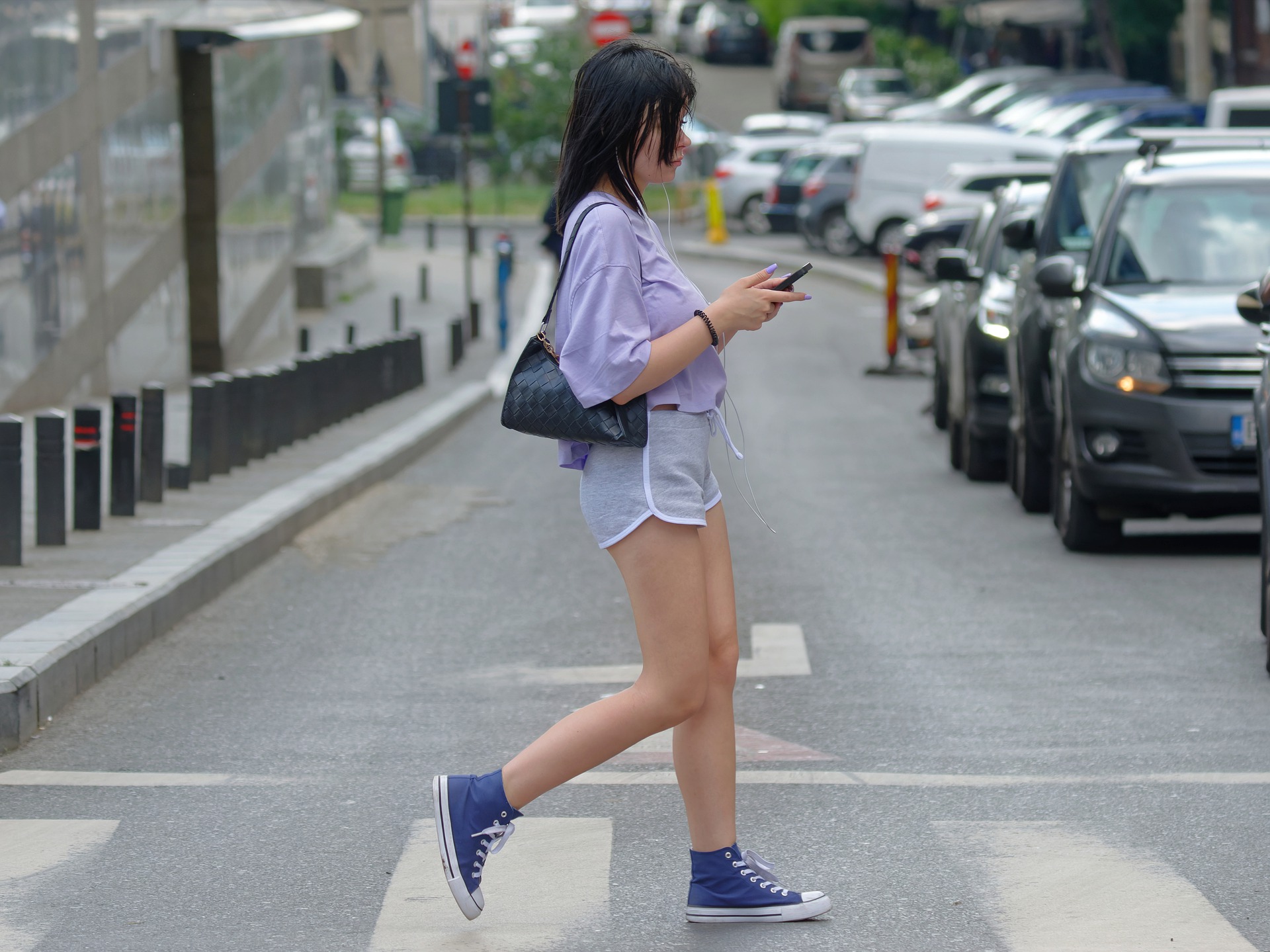 girl walking on a street checking a mobile