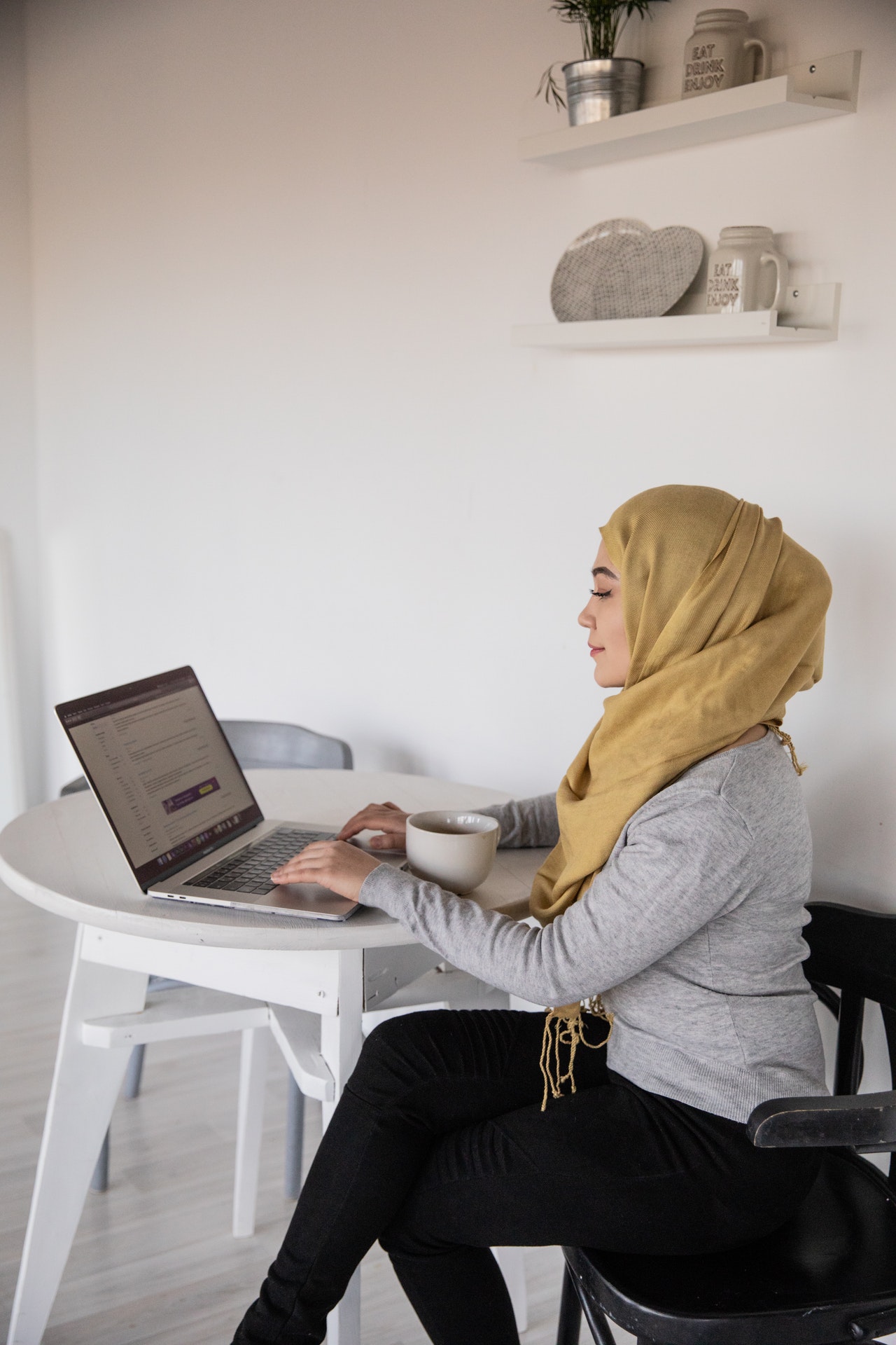 Girl wearing hijab working on laptop