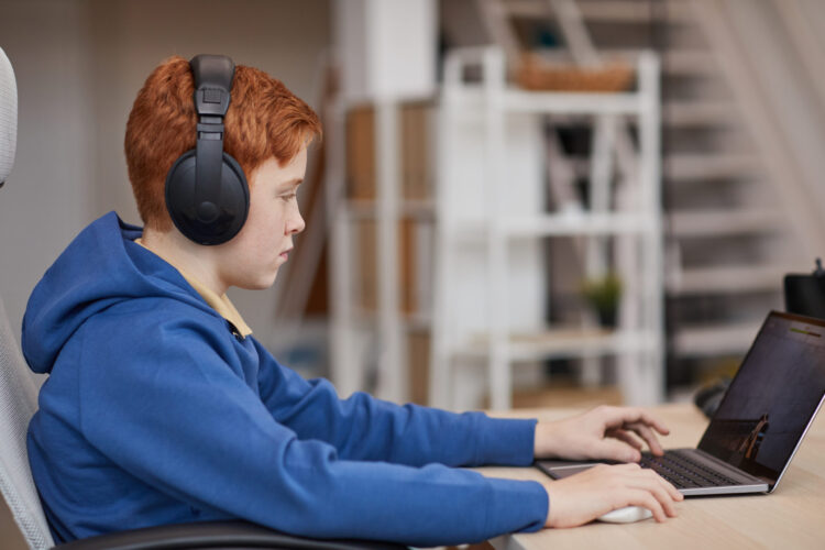 Teenage Boy Looking at A Laptop