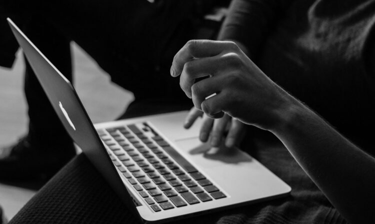 Black and gray picture of a woman on a laptop